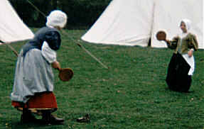 Children playing with a bat and ball.