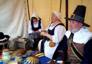 Women mending clothes under cover in the suttlers tent.